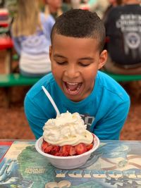 Smiling boy looking at dessert at restaurant