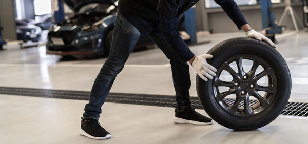 Low section of man with high angle view of tire