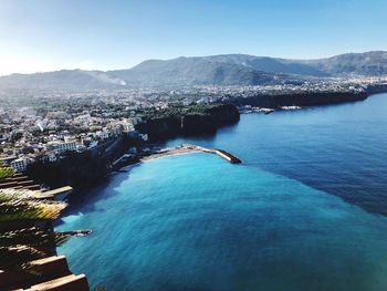 High angle view of sea and buildings against sky