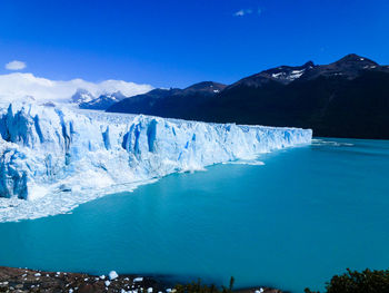 Scenic view of snowcapped mountains against blue sky