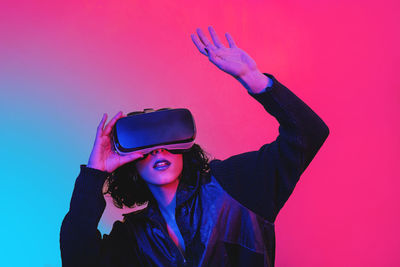 Woman is using virtual reality viewer. modern woman portrait with trendy look and bright colors.