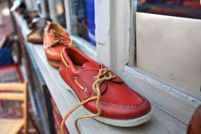 Close-up of red shoes hanging on metal chair