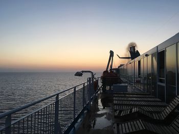 Pier on sea against clear sky during sunset