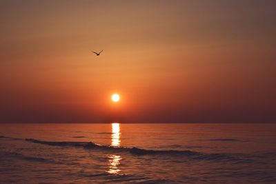 Scenic view of sea against orange sky