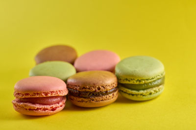 Close-up of multi colored candies against yellow background