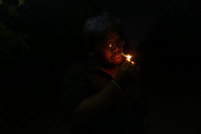 Man igniting cigarette in dark