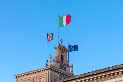 Low angle view of flag against clear blue sky