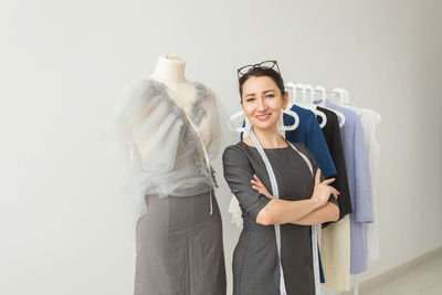 Smiling young woman standing in rack