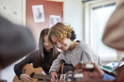 Teenagers attending guitar lesson