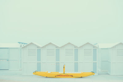 Yellow hut on beach against clear sky