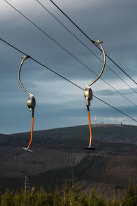 Electricity pylon on field against sky