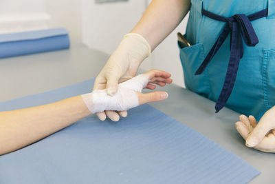 Midsection of doctor holding patient hand