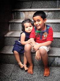 Portrait of a smiling girl sitting on staircase