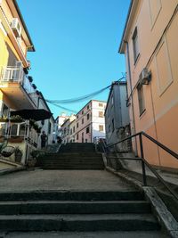 Low angle view of buildings in town against blue sky