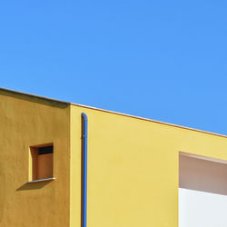 Low angle view of yellow building against sky