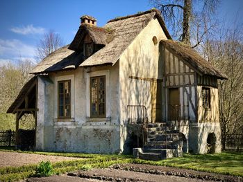 Exterior of abandoned house on field against sky