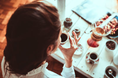 High angle view of woman holding coffee cup