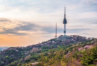 Communications tower and buildings against sky