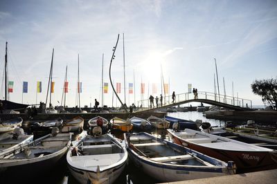 Boats moored at harbor against sky