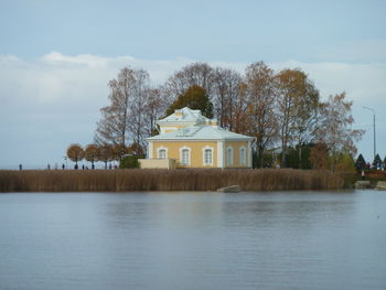 Building by lake against sky
