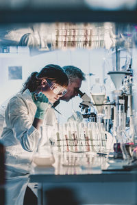 Side view of female doctor examining chemical in laboratory