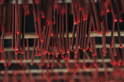 Full frame shot of red incense sticks hanging