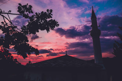 Silhouette of temple building against cloudy sky