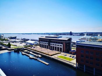 High angle view of buildings by sea against clear sky