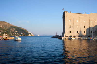 Boats in sea against buildings