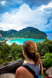 Rear view of woman relaxing on beach