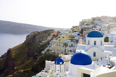 Panoramic view of oia village on overhanging cliff, santorini island, greece