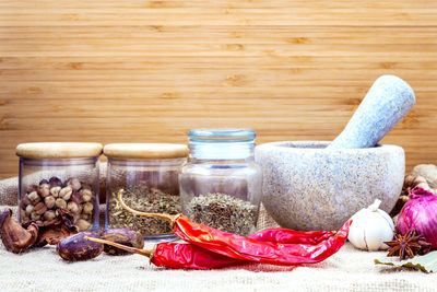 Various spices with mortar and pestle on table