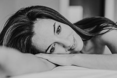 Close-up of thoughtful woman lying on bed at home