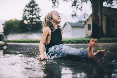 Full length of girl sitting in water