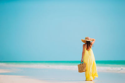 Woman standing on beach against sky