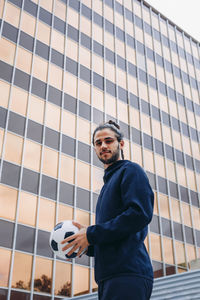 Player with soccer ball against glass wall