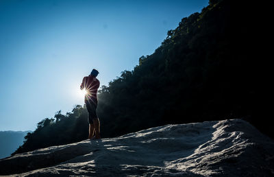 Low angle view of man standing on mountain