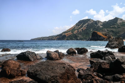 Scenic view of sea and mountains against sky