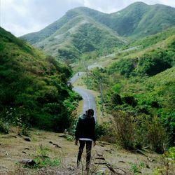 Rear view of man walking on mountain road