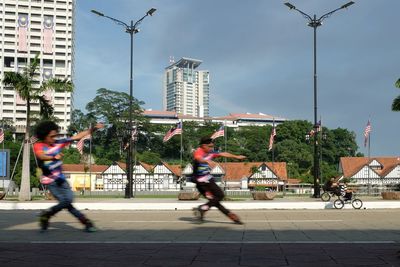 People on street in city against sky