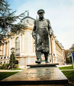 Low angle view of statue against building in city