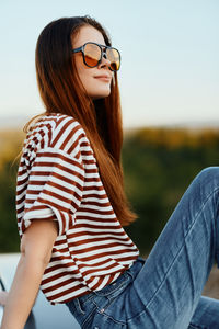 Portrait of young woman sitting on field