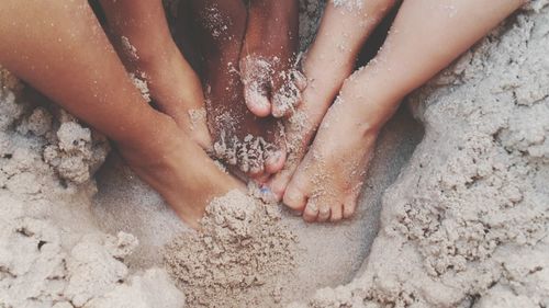 Low section of woman on wet sand at beach