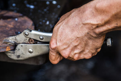 Cropped hand working on metal in workshop