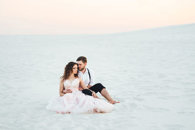 Young couple sitting on beach