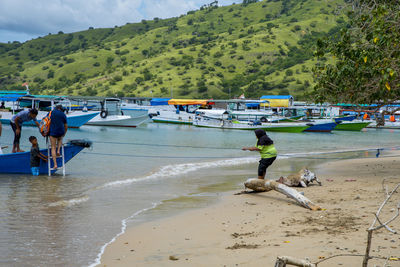 People at beach against mountains