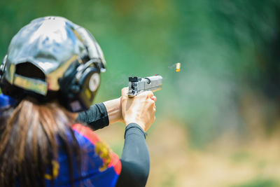 Rear view of woman target shooting