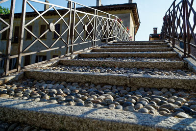 Staircase by stone wall against sky