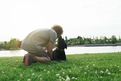 Rear view of woman sitting on field