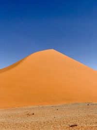 Scenic view of desert against clear blue sky